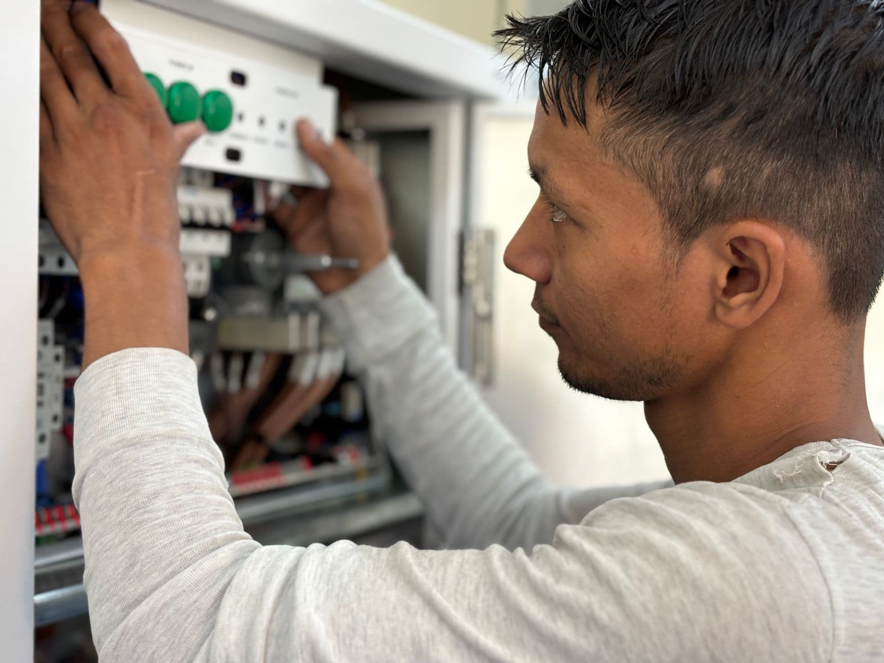 Elevator technician inspecting a control panel during a maintenance visit