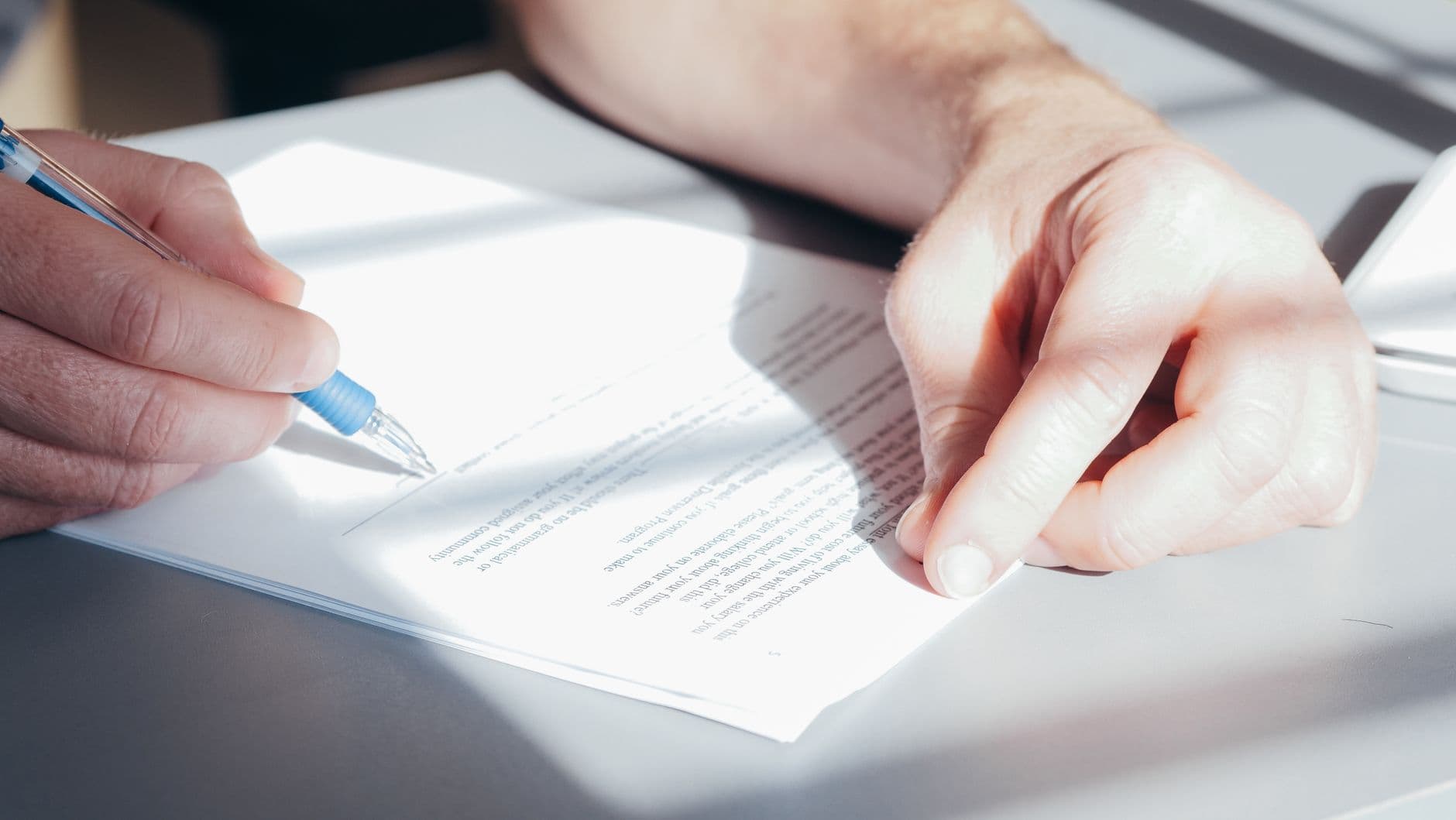 Building manager reviewing an elevator proposal document at a desk before signing