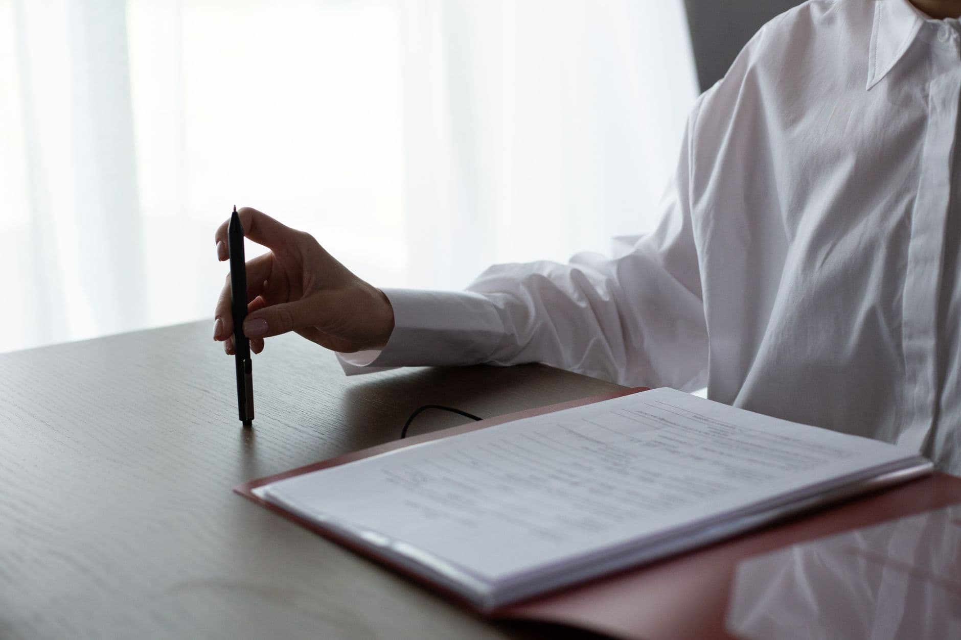 Person reviewing a multi-page elevator proposal document at a desk with a highlighter and calculator