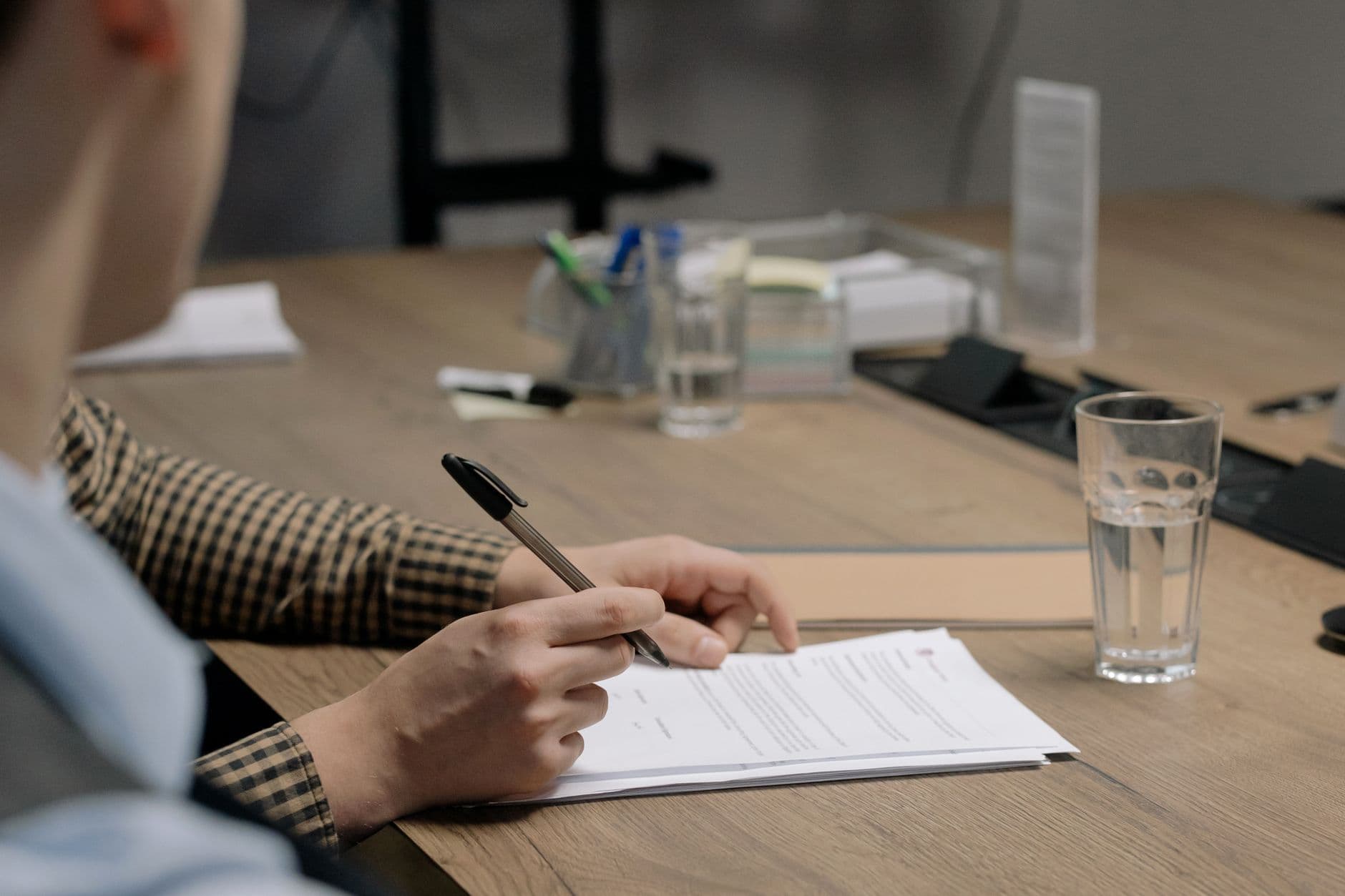 Building manager reviewing an elevator maintenance contract with a pen in hand at a conference table