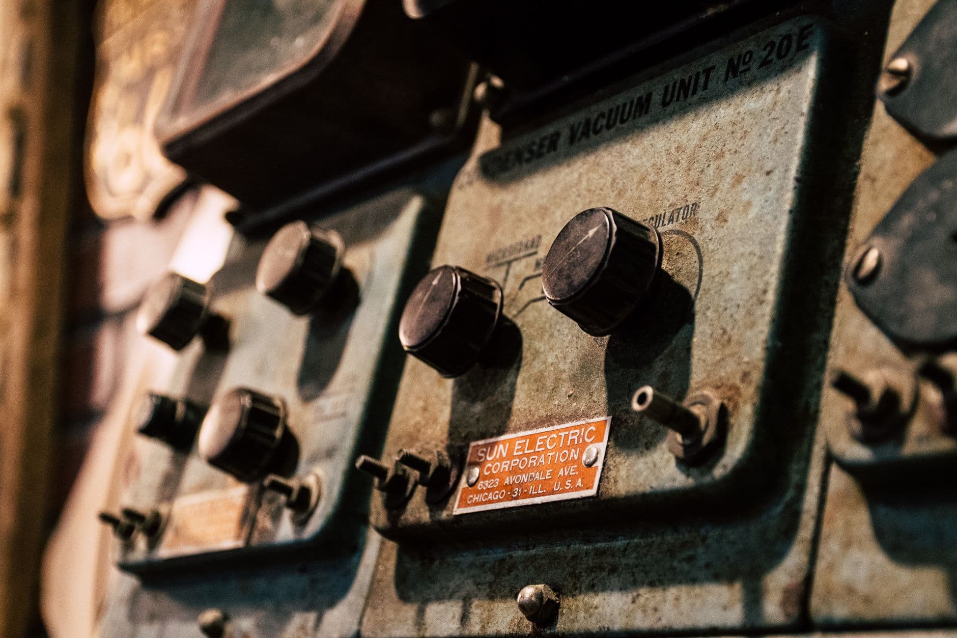 Technician inspecting an aging elevator control panel with relay-based wiring in a machine room